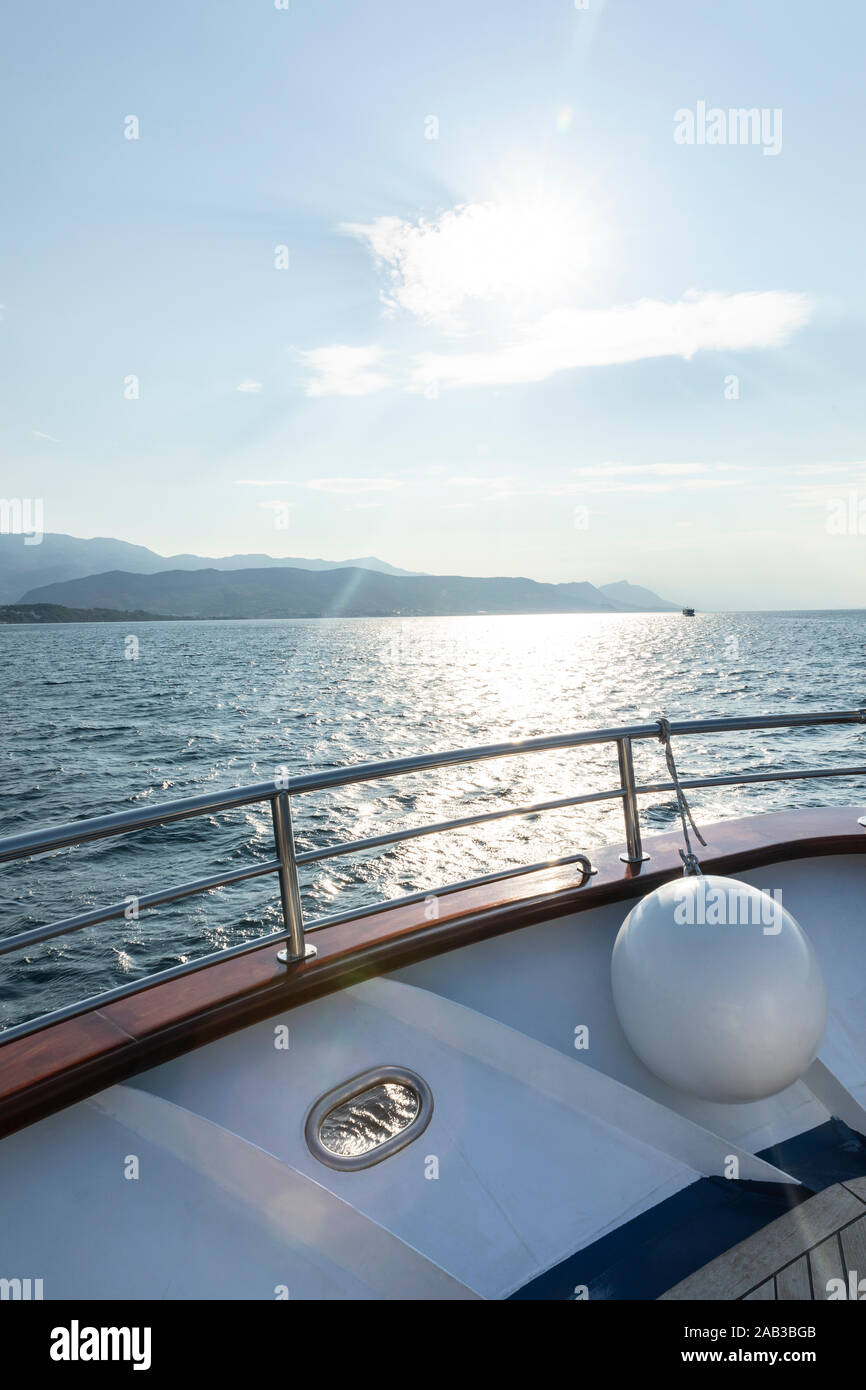 Beautiful view over the adriatic sea with islands and the sun shot from the  upper deck on board of a boat. Fender hanging on the inside. White and blu  Stock Photo -