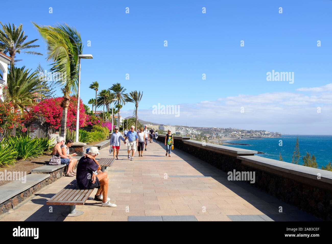 MASPALOMAS, SPAIN - JANUARY 23, 2019: Vacationers at the promenade of Playa del Ingles, in Maspalomas, in the Canary Islands, Spain, a popular winter Stock Photo
