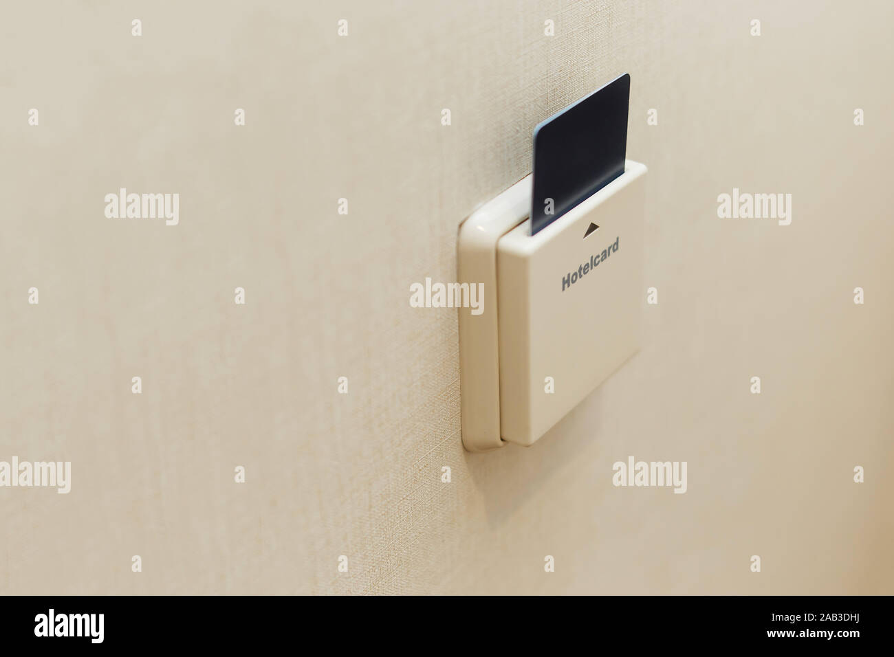 Electronic lock with card inserted and light switches on wall in hotel room Stock Photo