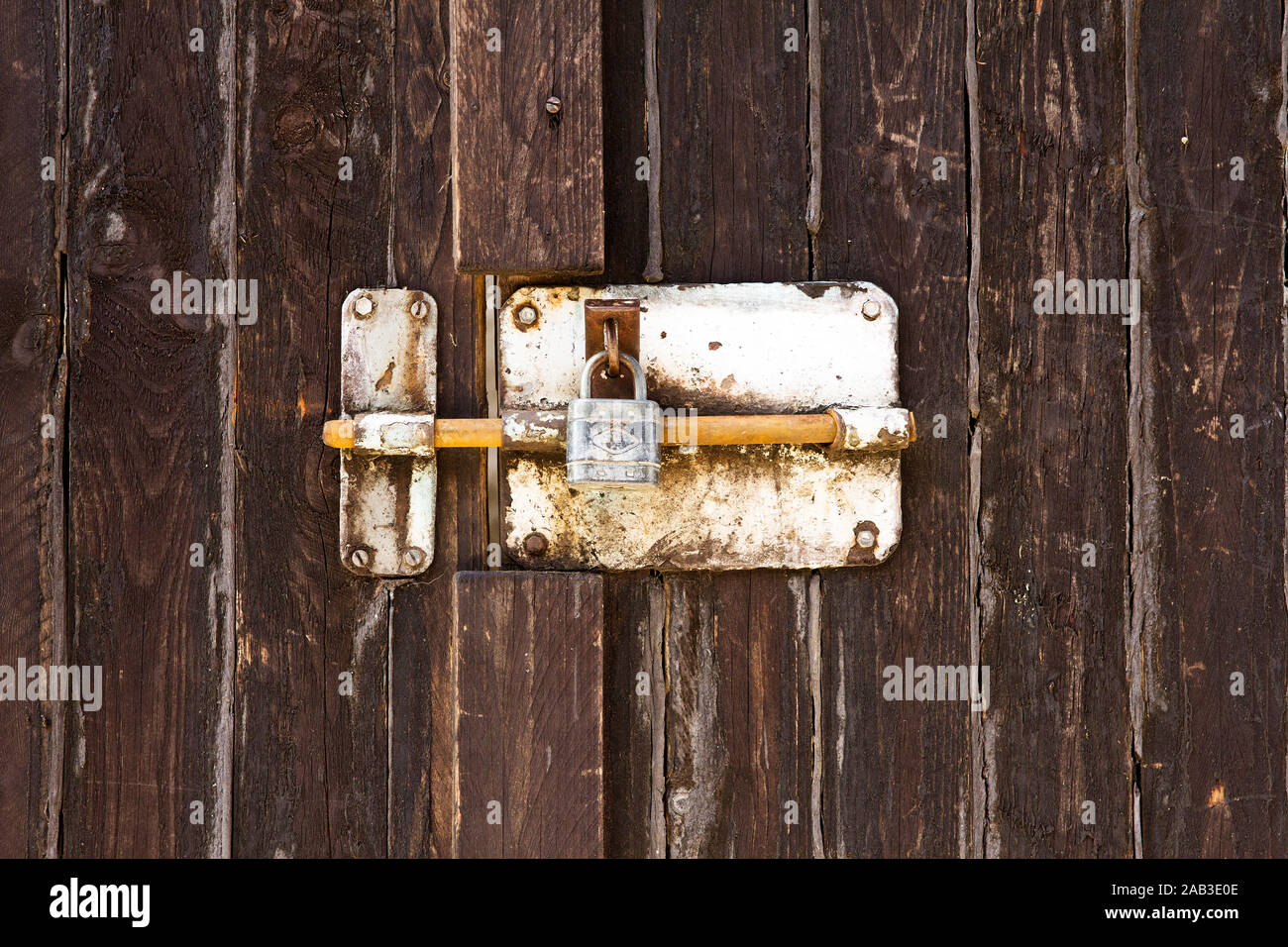 Verriegelung mit Vorhängeschloss an einem Holztor |Locking with a padlock on a wooden gate| Stock Photo