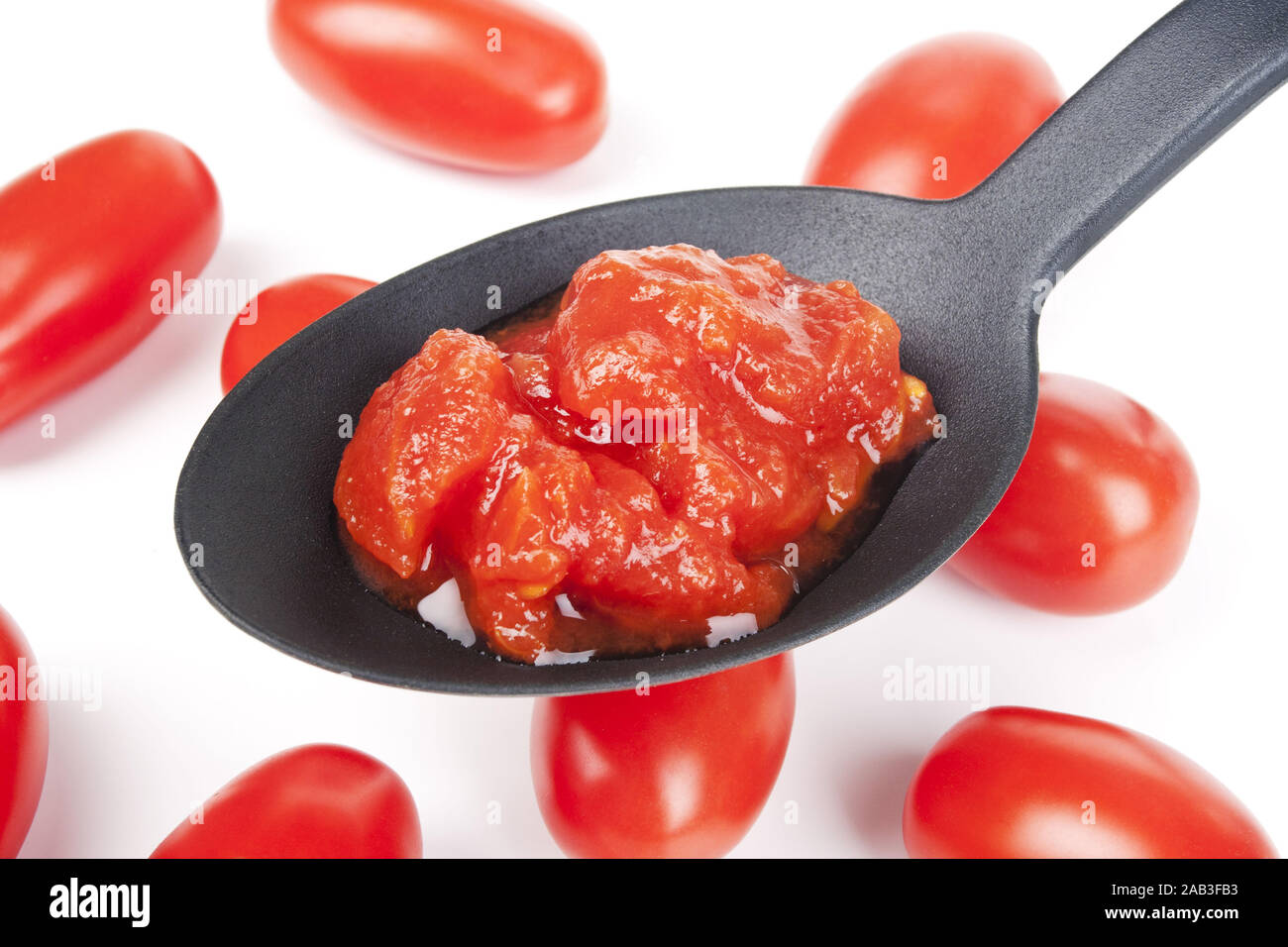 Passierte Tomaten auf einem Loeffel |Crushed tomatoes on a spoon| Stock Photo
