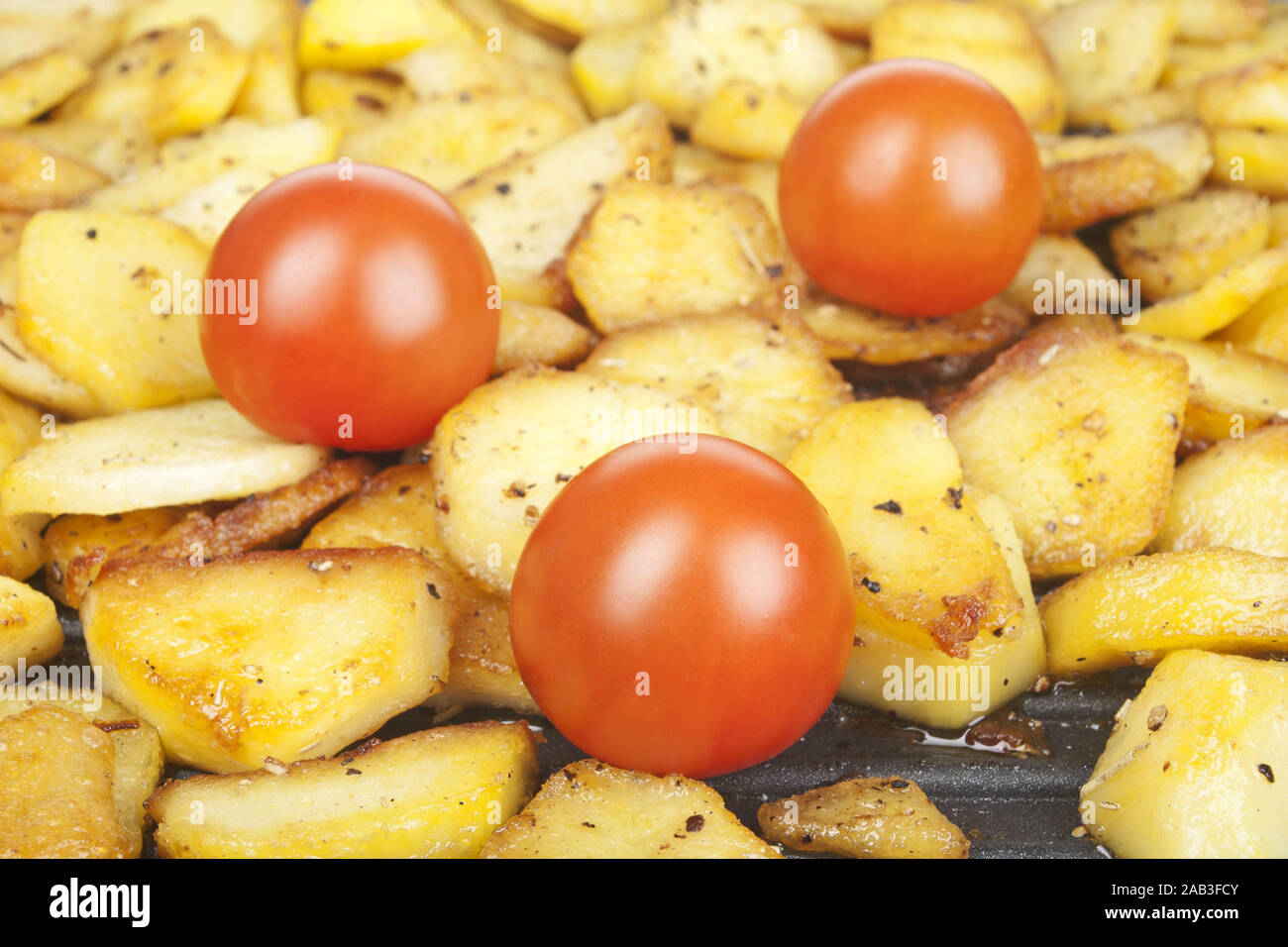 Bratkartoffeln und Tomaten in einer Pfanne |Fried potatoes and tomatoes in a pan| Stock Photo