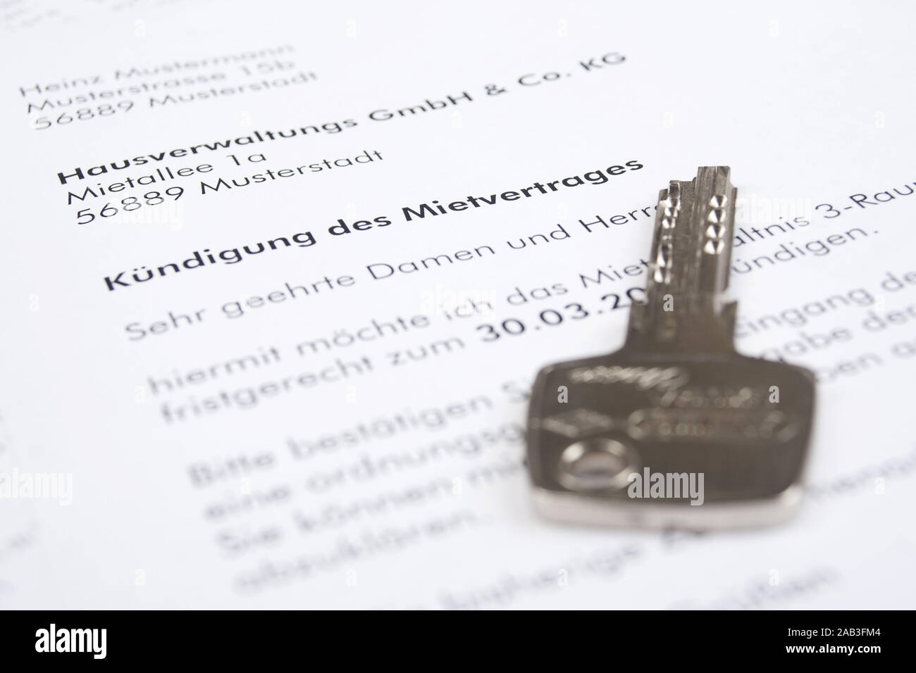 Schriftliche Kuendigung eines Mietvertrages mit einem Schluessel |Written notice of termination of a tenancy agreement with a key| Stock Photo
