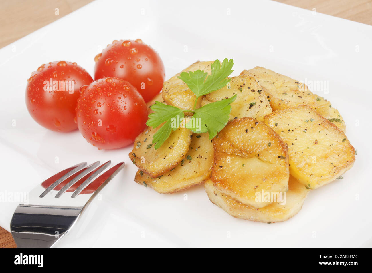 Bratkartoffeln und Tomaten auf einem Teller |Fried potatoes and tomatoes on a plate| Stock Photo