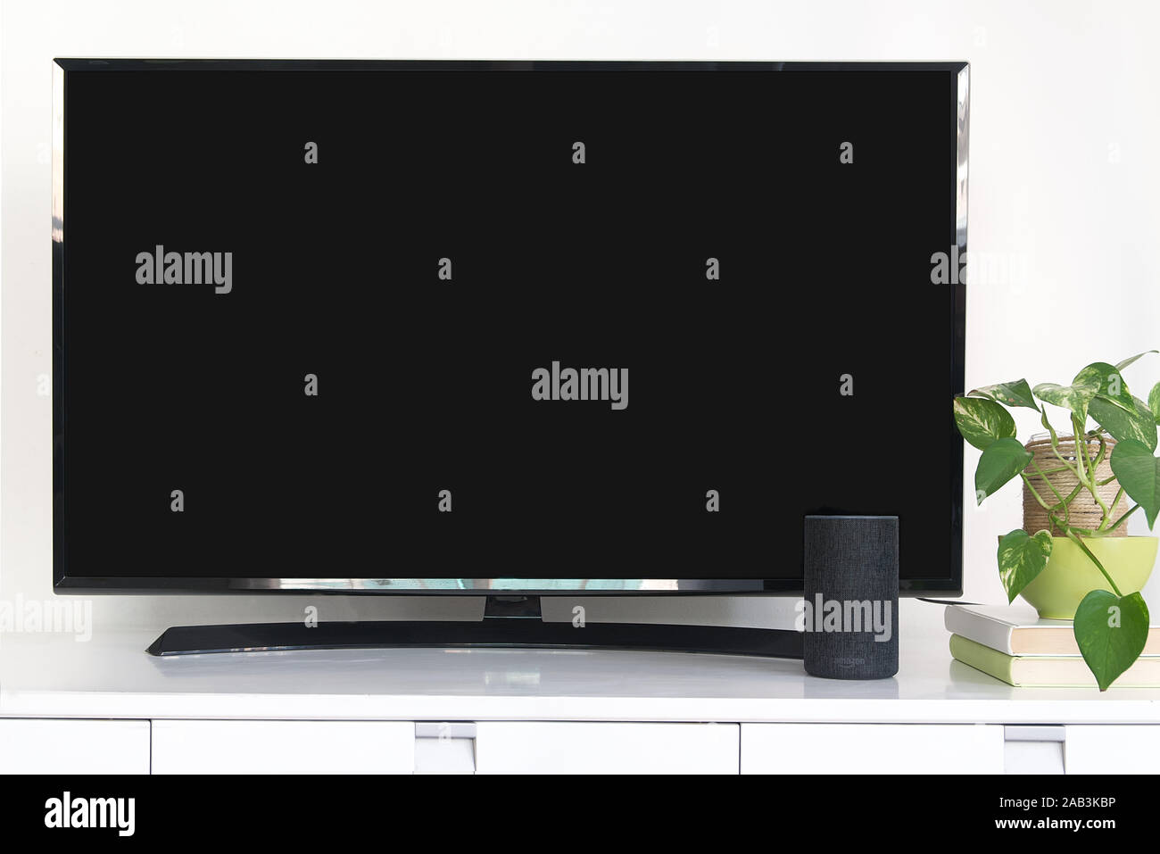 Alexa Echo Intelligent speaker device as home automation system to control a smart television. Living room with a black screen of a tv. Stock Photo