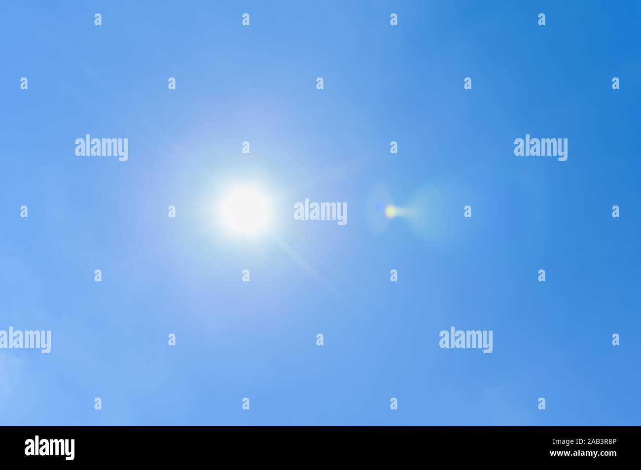 Clear blue sky sun light with Real Lens flare out of focus blue sky no could background Stock Photo
