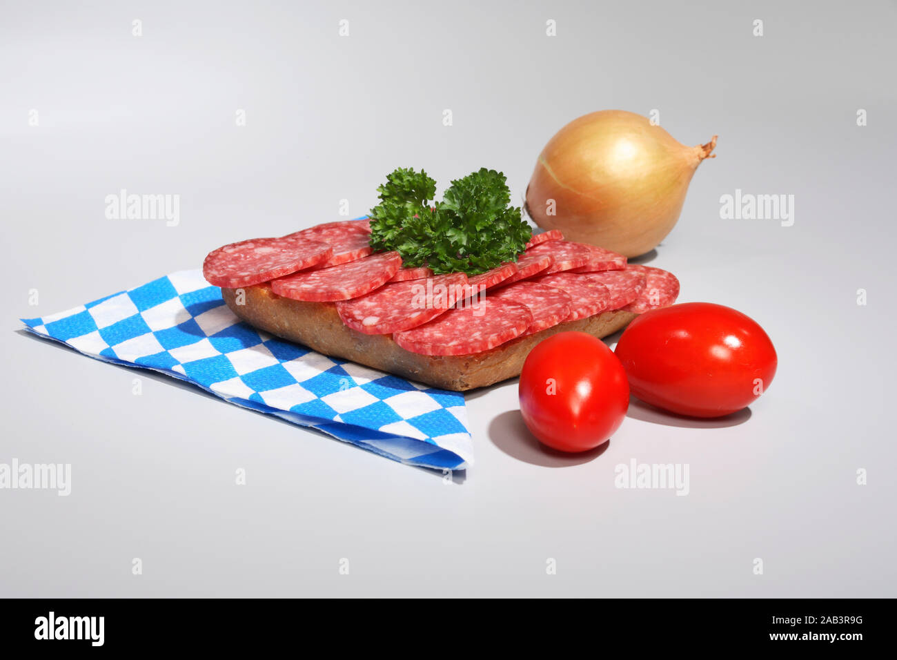 Vollkornbroetchen mit Salami, Tomaten und Zwiebel Stock Photo