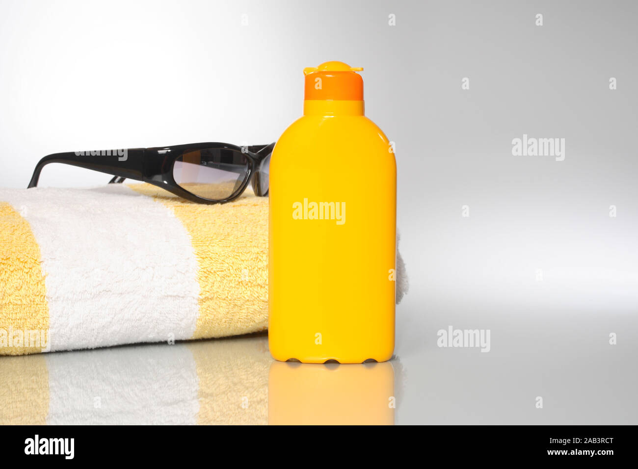 Badelaken mit Sonnenmilch und Sonnenbrille Stock Photo