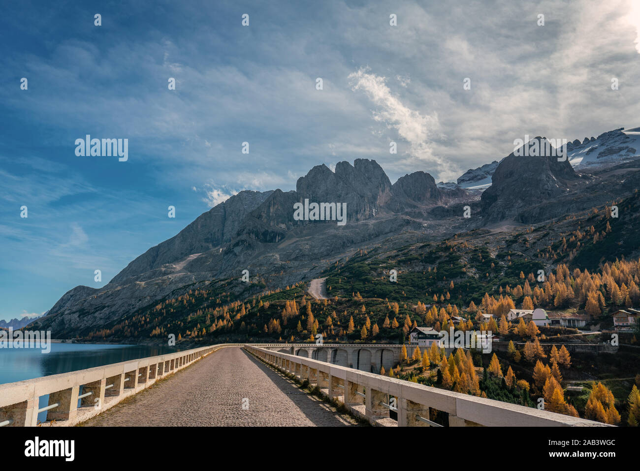 Street on top of the Fedaia reservoir dam at the foot of the Marmolada mountains in South Tyrol on a sunny and clear autumn day Stock Photo