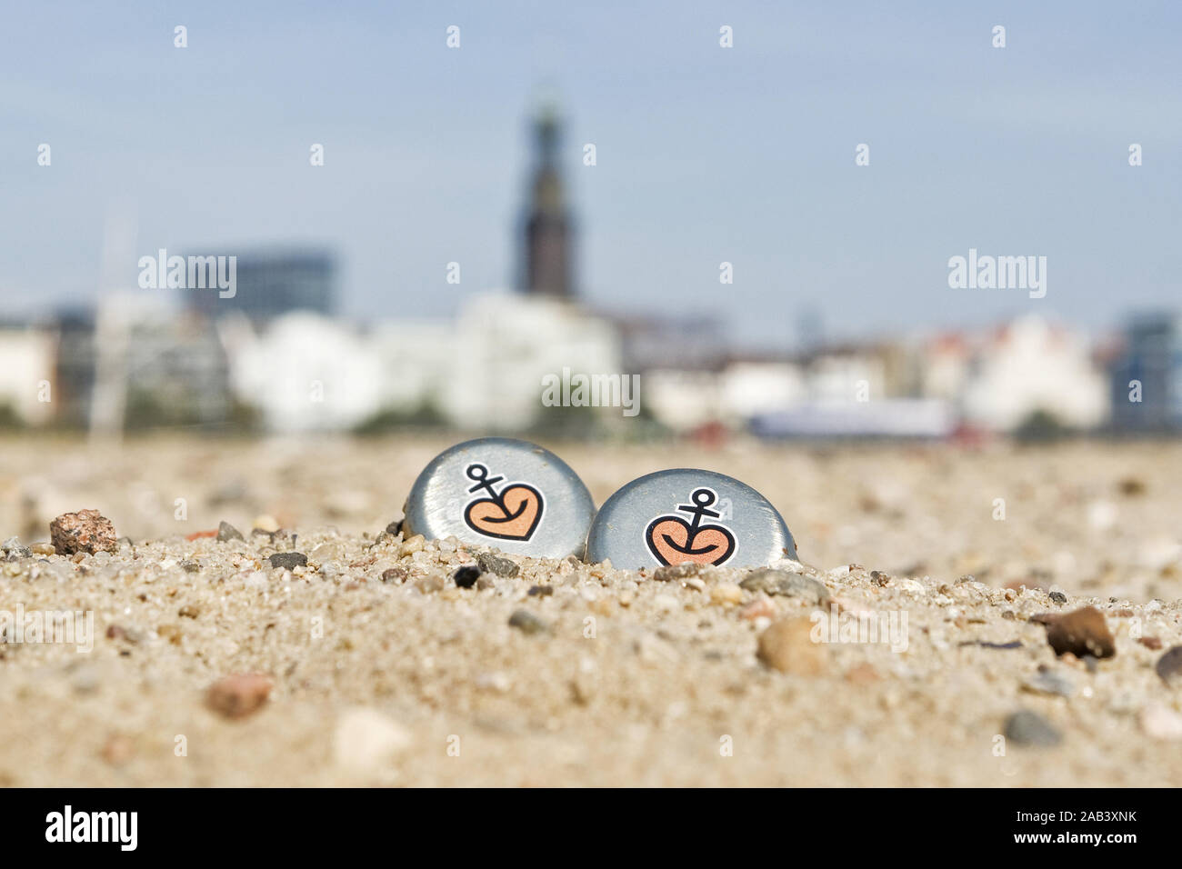 Zwei Astra- Kronkorken am Strand im Hamburger Hafen |Two Astra crown corks on the beach in the port of Hamburg| Stock Photo