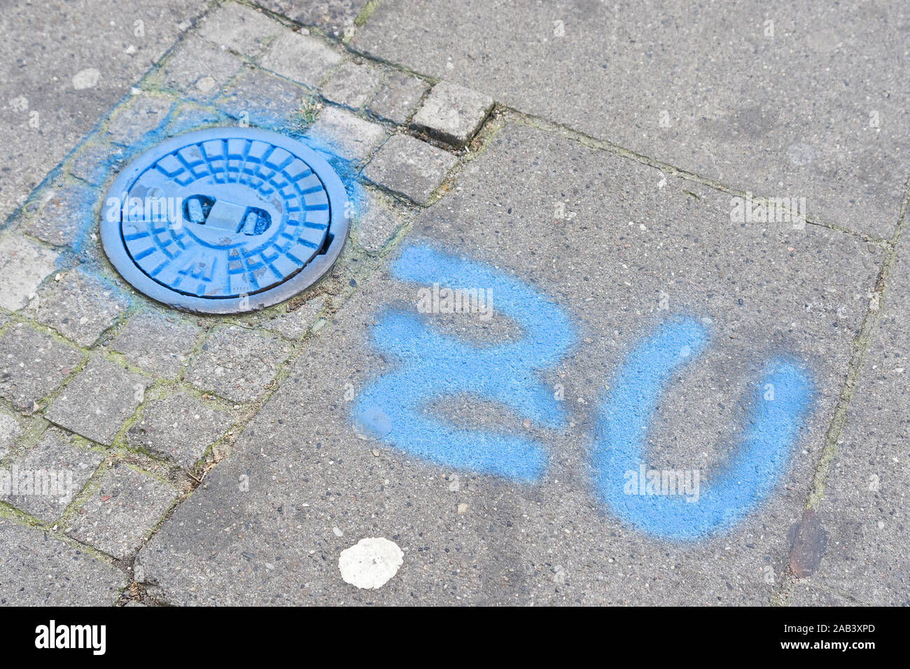 Absperrventil auf einem Gehweg mit dem Vermerk „ZU“ |Shut-off valve on a sidewalk with the words 'ZU'| Stock Photo