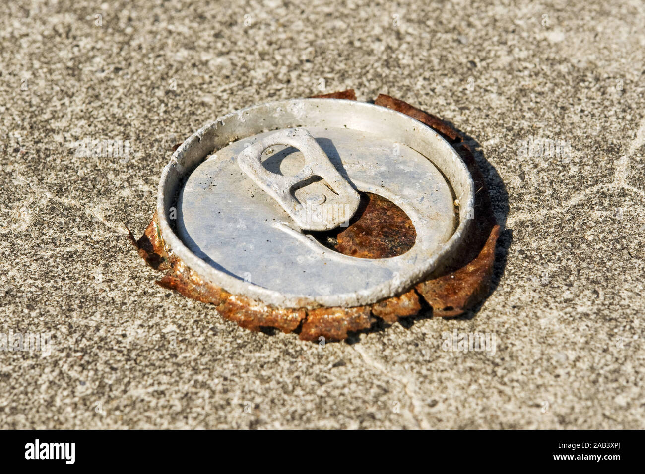 Reste einer alten Bierdose auf einem Parkplatz |Remains of an old beer can in a parking lot| Stock Photo