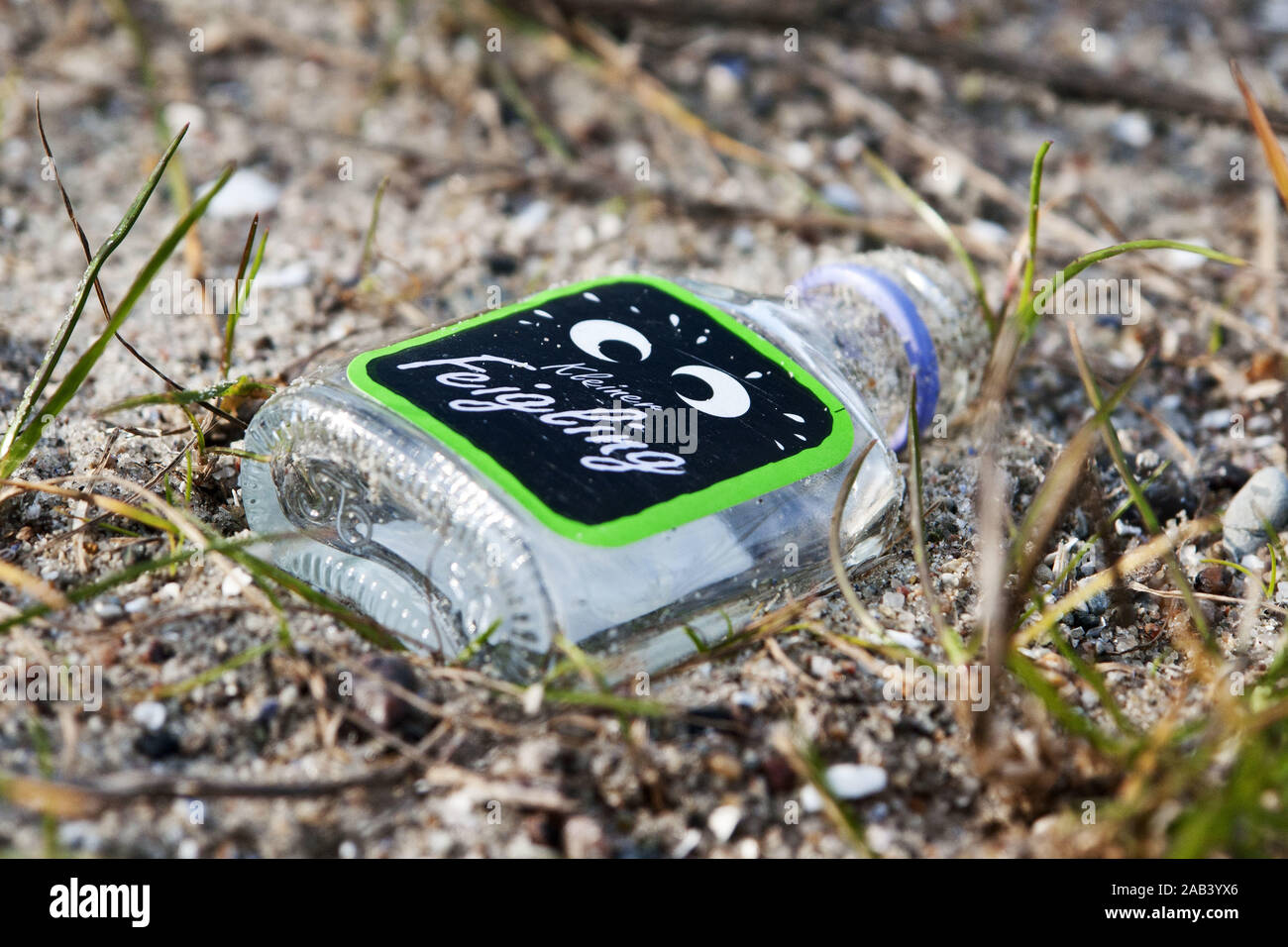 Eine Flasche Kleiner Feigling am Strand |A bottle of little coward on the beach| Stock Photo