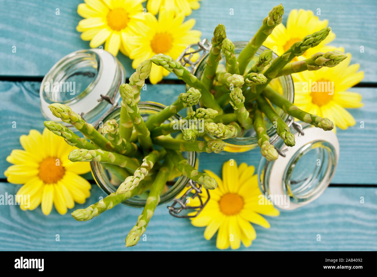 Grüner Spargel in Einmachgläser, anbei einige gelbe Blüten |Green asparagus in jars, here are some yellow blossoms| Stock Photo