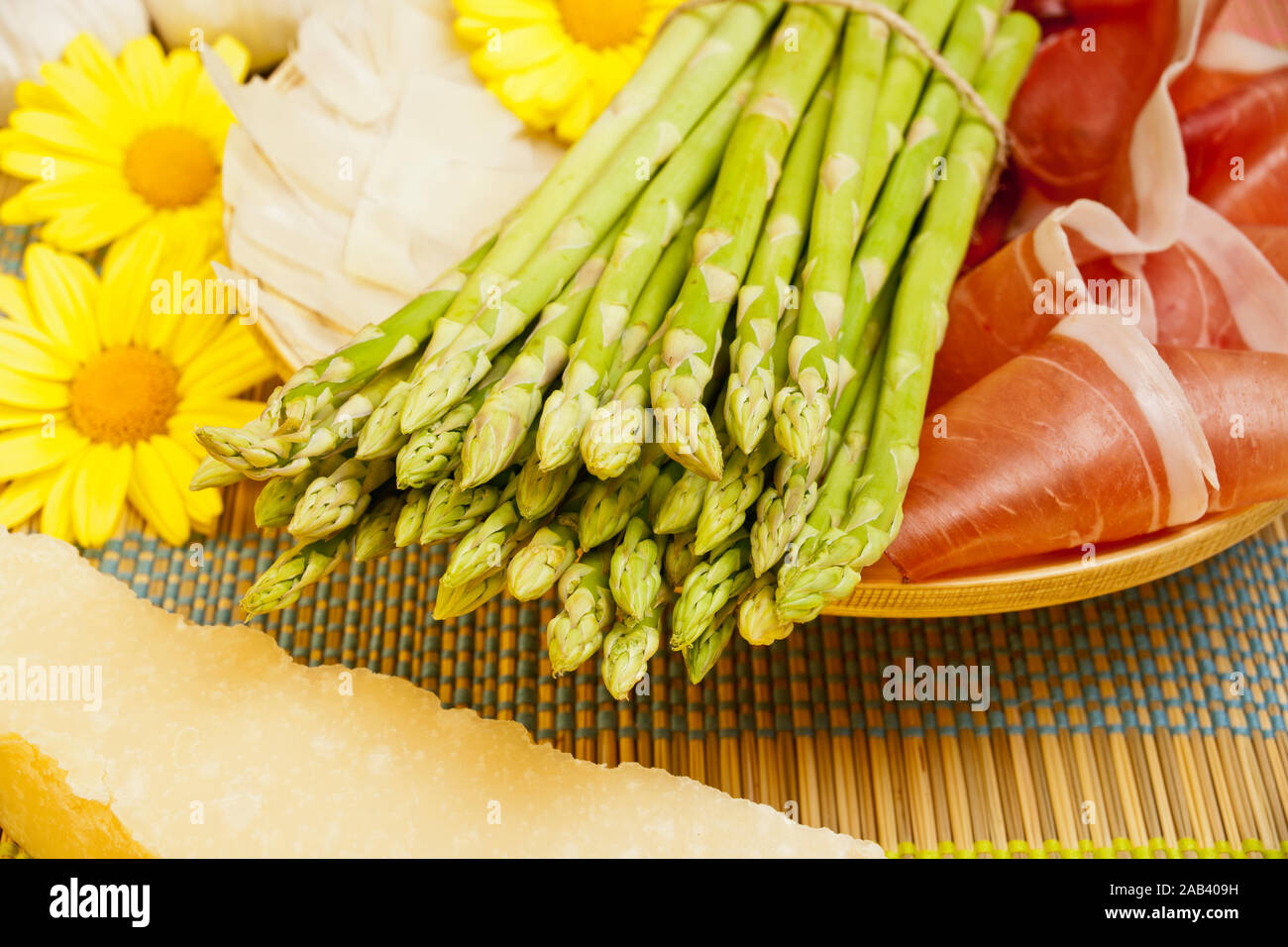 Grüner Spargel in einer Holzschale zusammen mit Schinken und Parmesan |Green asparagus in a wooden bowl with ham and Parmesan| Stock Photo