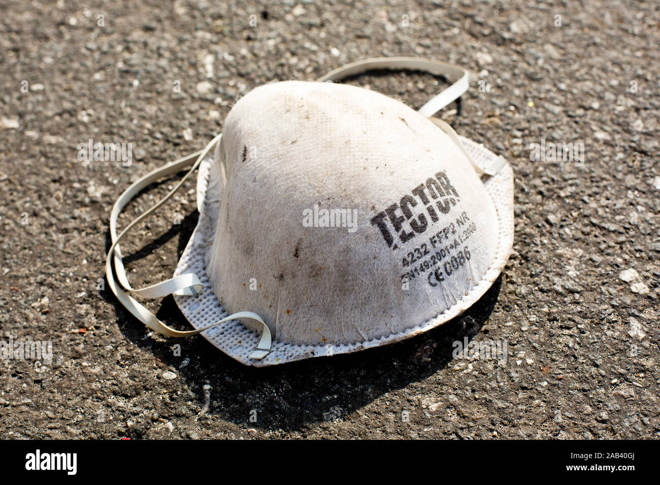 Eine gebrauchte Schutzmaske liegt auf dem Asphalt |A used protective mask lies on the asphalt| Stock Photo