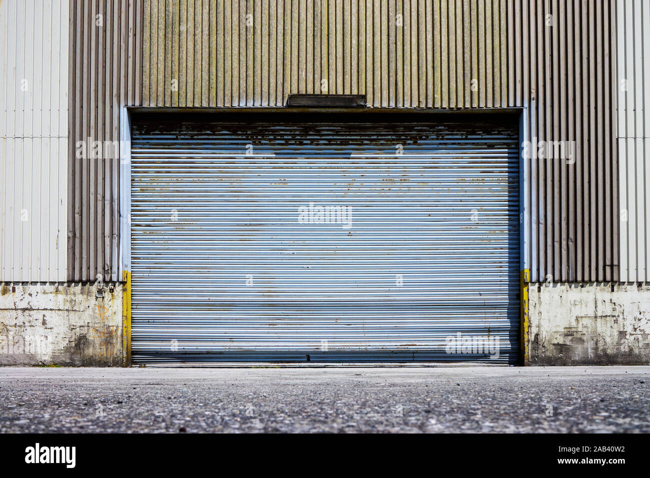 Ein geschlossenes Rolltor von einem altem Lagerhaus im Hafen |A closed shutter door of a warehouse in the port| Stock Photo