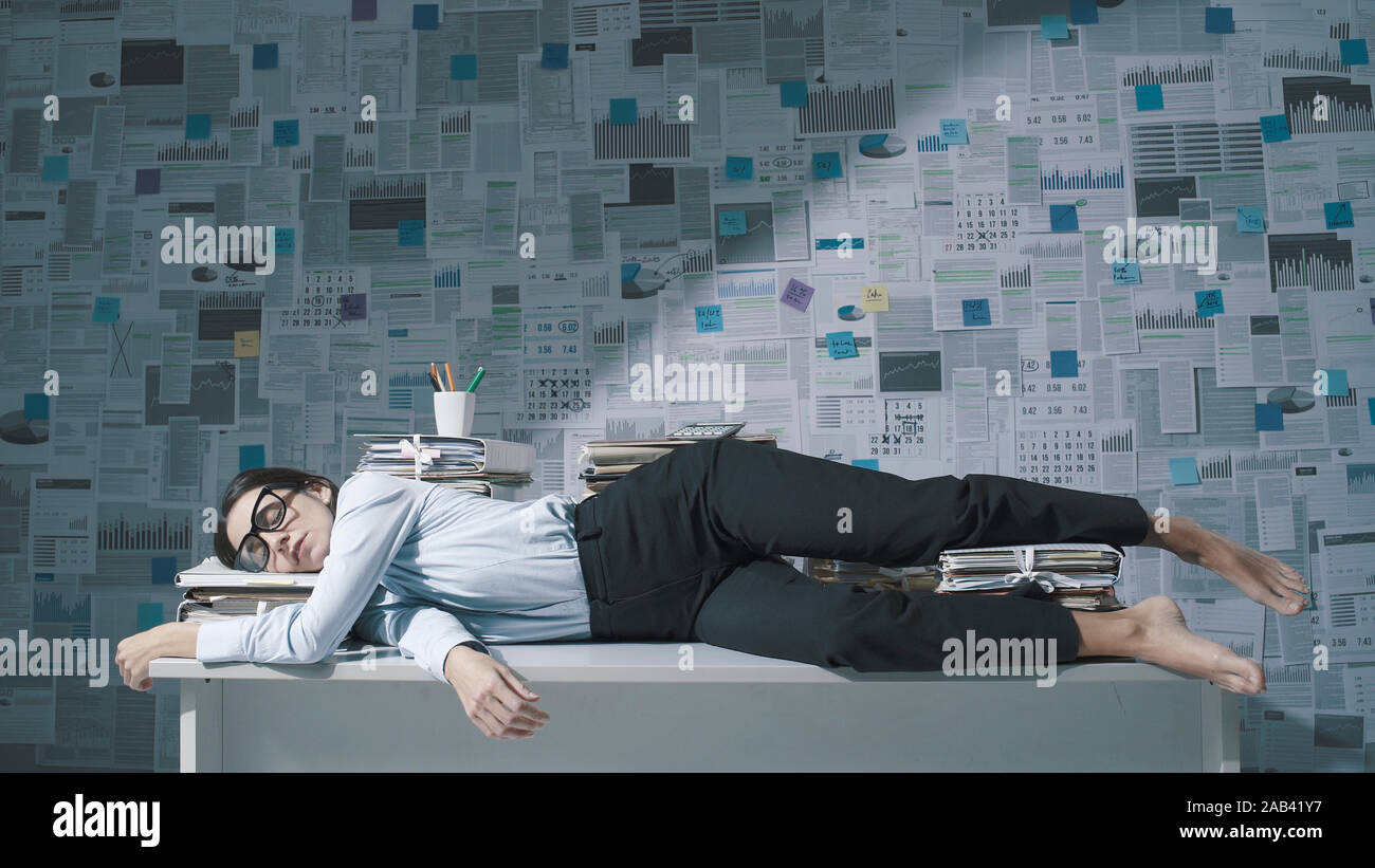 Exhausted Stressed Businesswoman Lying Down On The Desk And