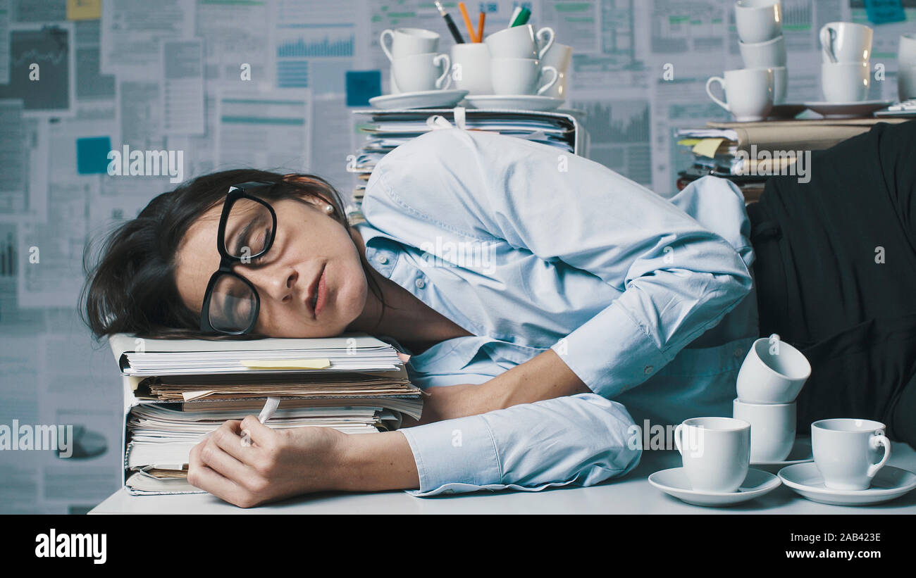 https://c8.alamy.com/comp/2AB423E/exhausted-business-woman-sleeping-in-the-office-she-is-lying-down-on-the-desk-surrounded-by-paperwork-and-empty-cups-of-coffee-2AB423E.jpg