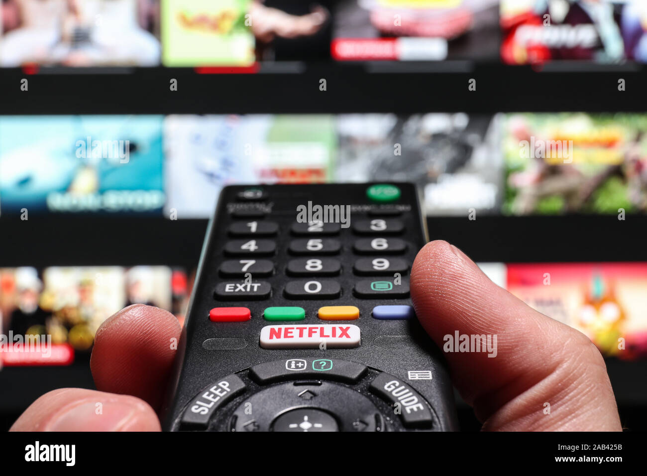 Watching Netflix on a smart Television using the Netflix button on a TV remote control Stock Photo