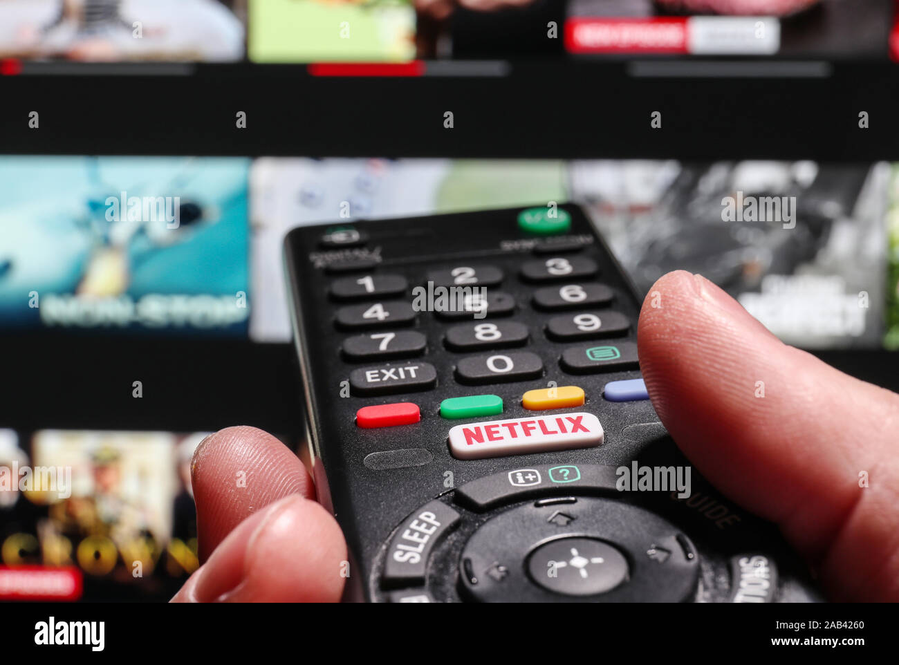 Watching Netflix on a smart Television using the Netflix button on a TV remote control Stock Photo