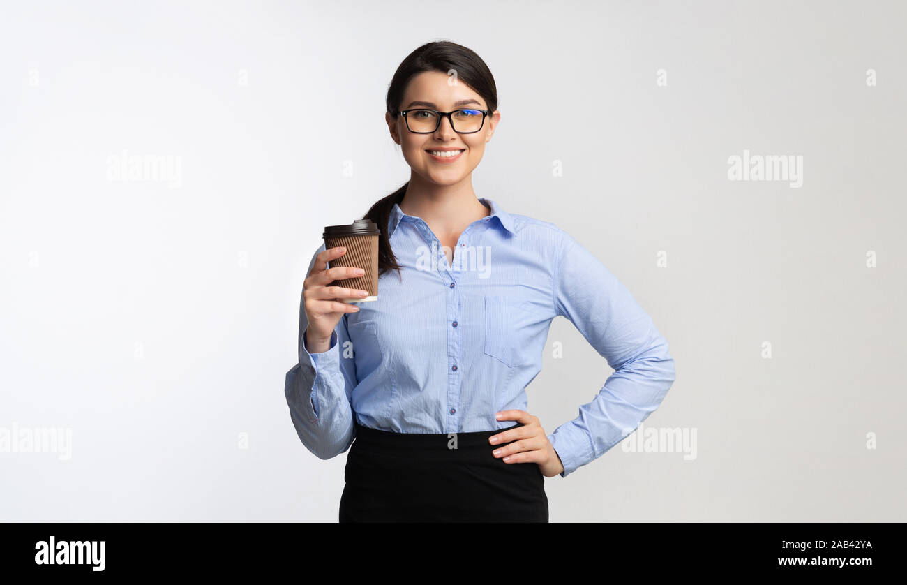 Smiling Office Girl Holding Paper Coffee Cup Standing, Studio Shot Stock Photo