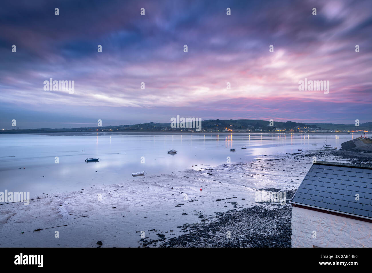 The first rays of dawn reflect in the still waters of the River Torridge at Instow in North Devon. Stock Photo