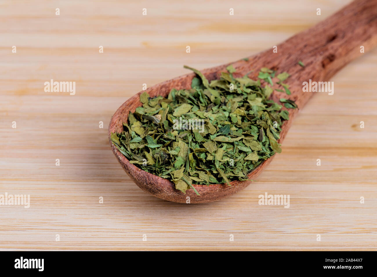 Wooden spoon fulled with delicious diced Parsley, a very popular garnish Stock Photo