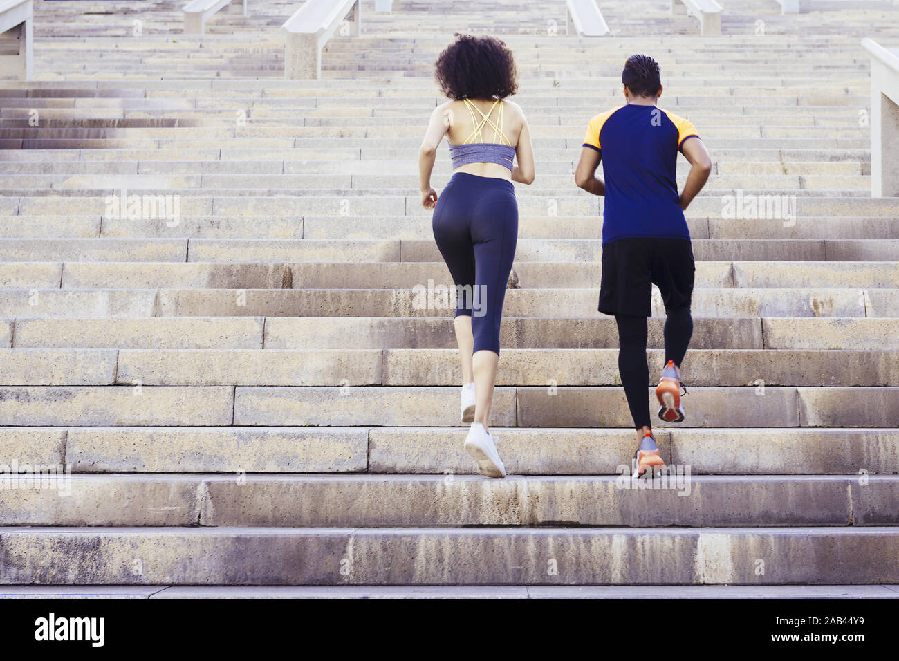 young runners couple running upstairs on city stairs, fitness, urban sports workout and healthy