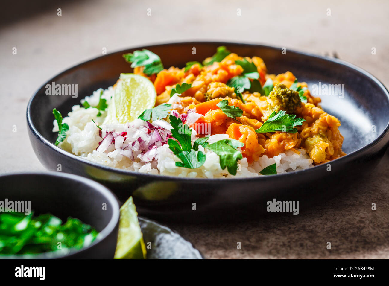 Vegetarian lentil stew with rice in a black plate. Healthy vegan food