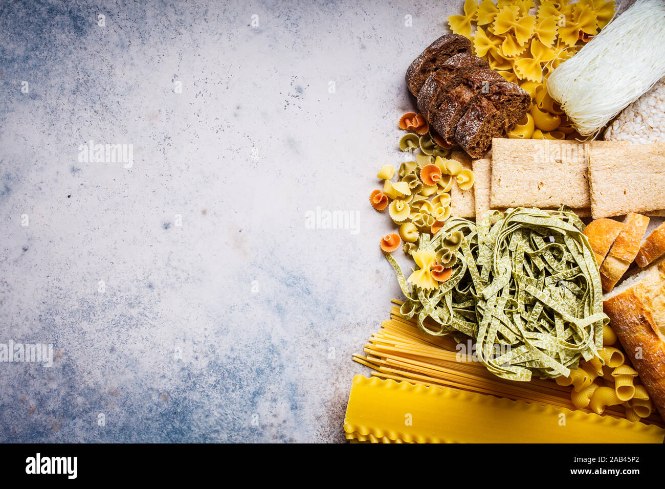 Various pasta background. Bread and different types of pasta on a gray-blue background, copy space. Stock Photo