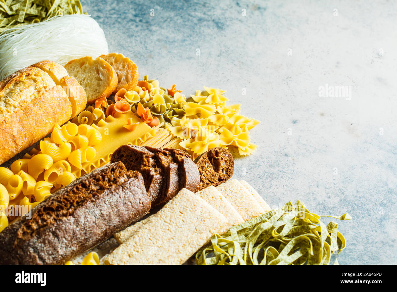 Various pasta background. Bread and different pasta on a gray-blue background, copy space. Stock Photo