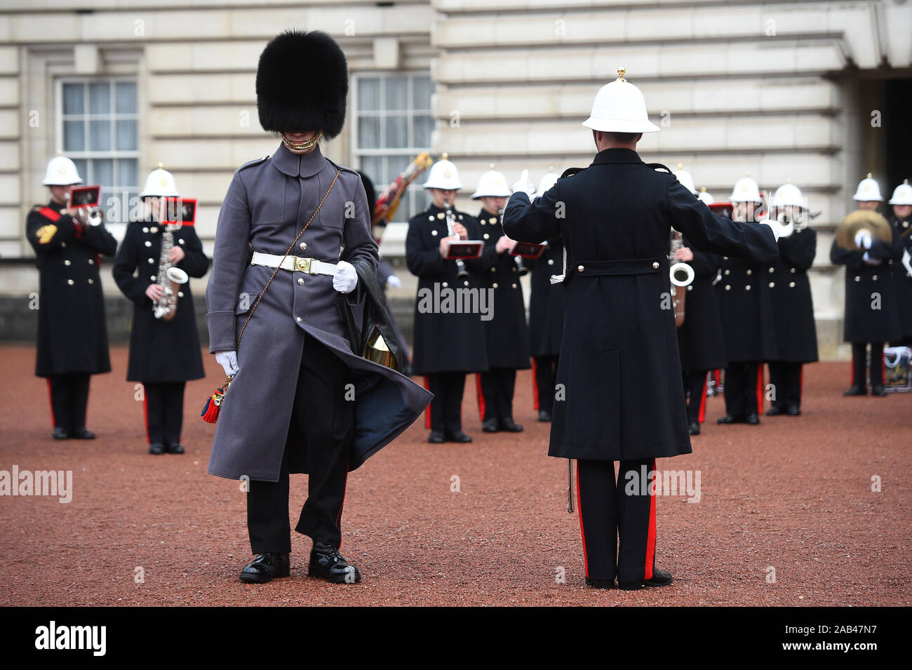 A Royal Navy officer (right) alongside a guardsman, as sailors from the Royal Navy perform the Changing of the Guard ceremony at Buckingham Palace, London, for the second time in its 357-year history. Stock Photo