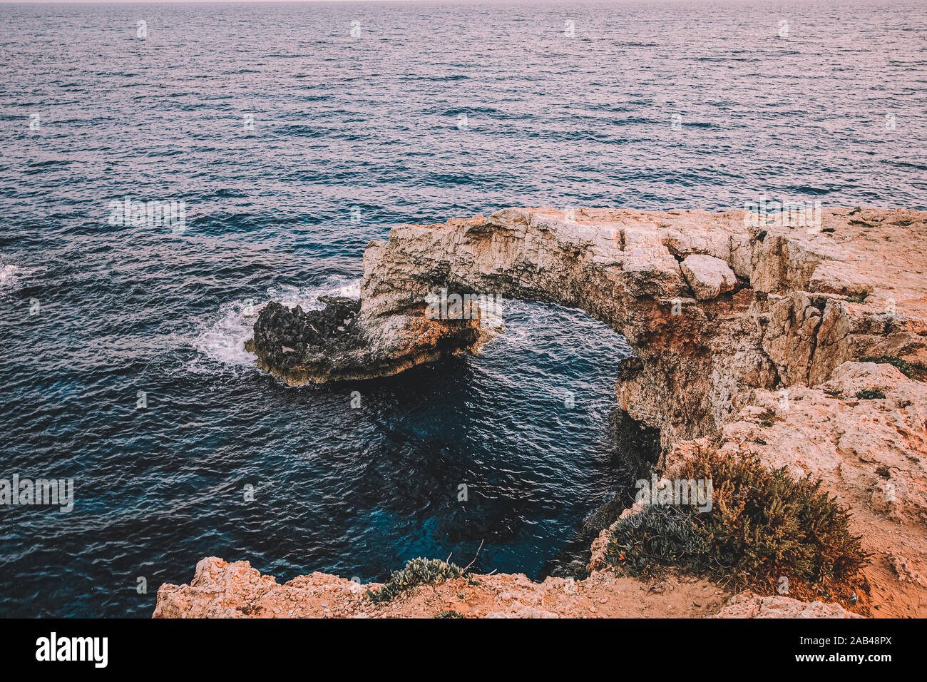 Beautiful natural rock arch near of Ayia Napa, Cavo Greco and Protaras on Cyprus island, Mediterranean Sea. View near of Legendary bridge lovers. Amaz Stock Photo