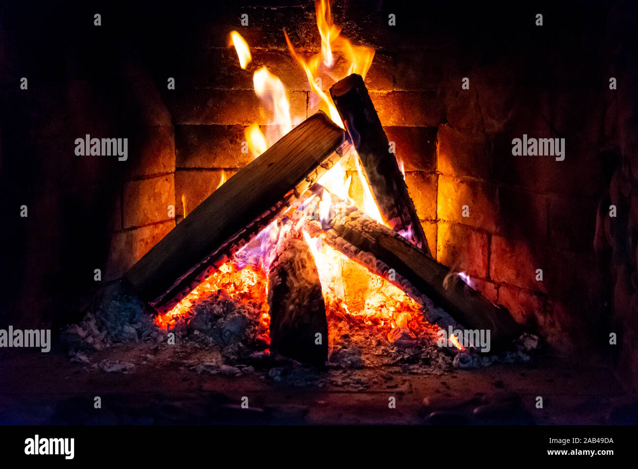 Flames in the fireplace. Burning wood. Brick fireplace Stock Photo