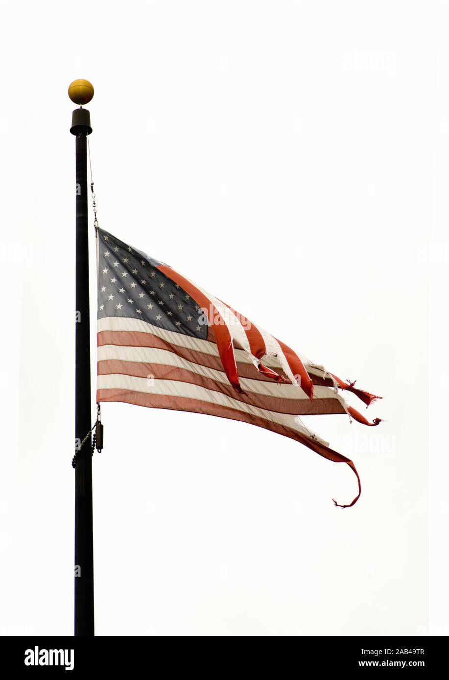 USA American flag at halfmast on a windy day. It is also known as halfstaff and is a symbol of