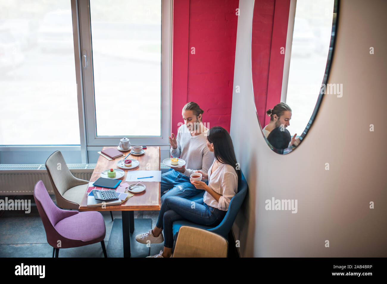 Entrepreneurs feeling good while tasting desserts and discussing menu Stock Photo