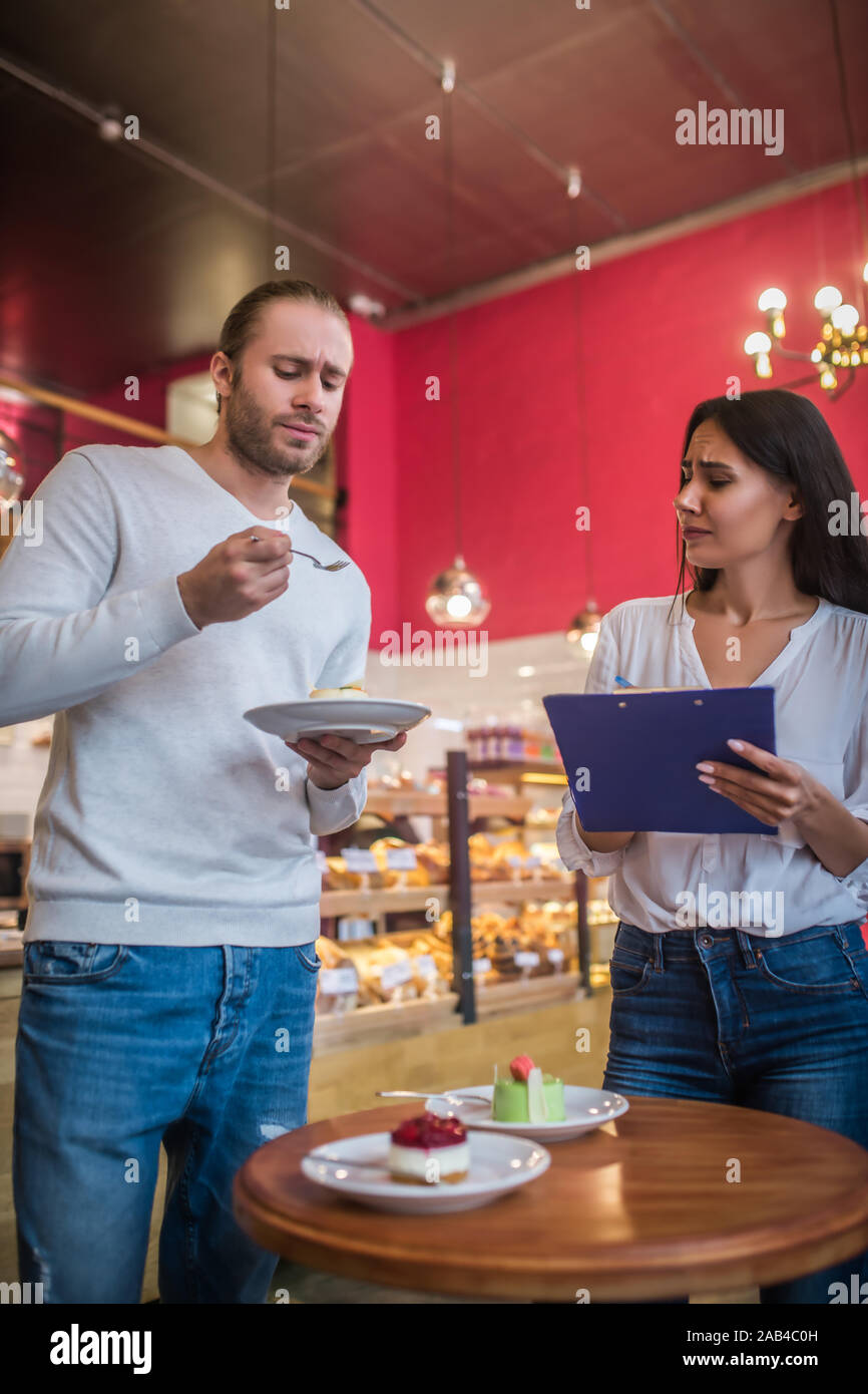 Couple feeling not satisfied with desserts while having quality check Stock Photo