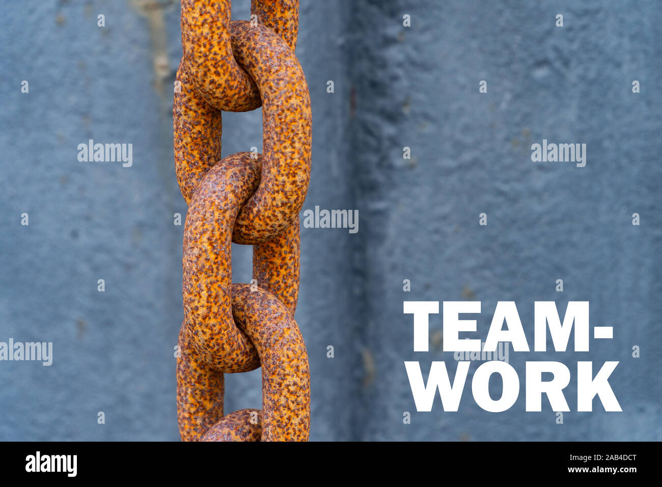 A big rusty chain with the words "Team Work" besides it - Motivation concept Stock Photo