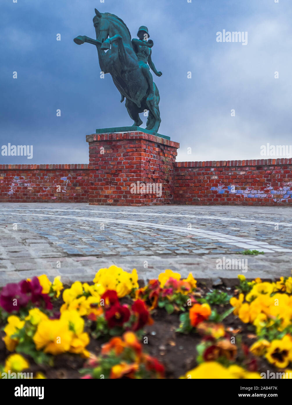 Memorial to the Second Transylvanian Hussars and colorful flower-bed in front of it on an overcast spring day. Stock Photo