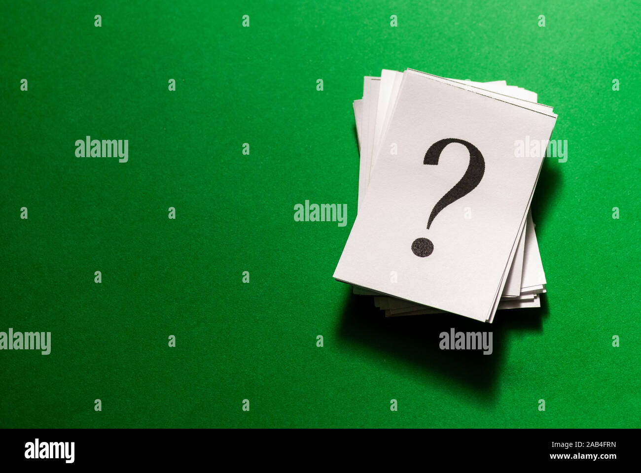 Pile of stacked question marks printed on white paper viewed from