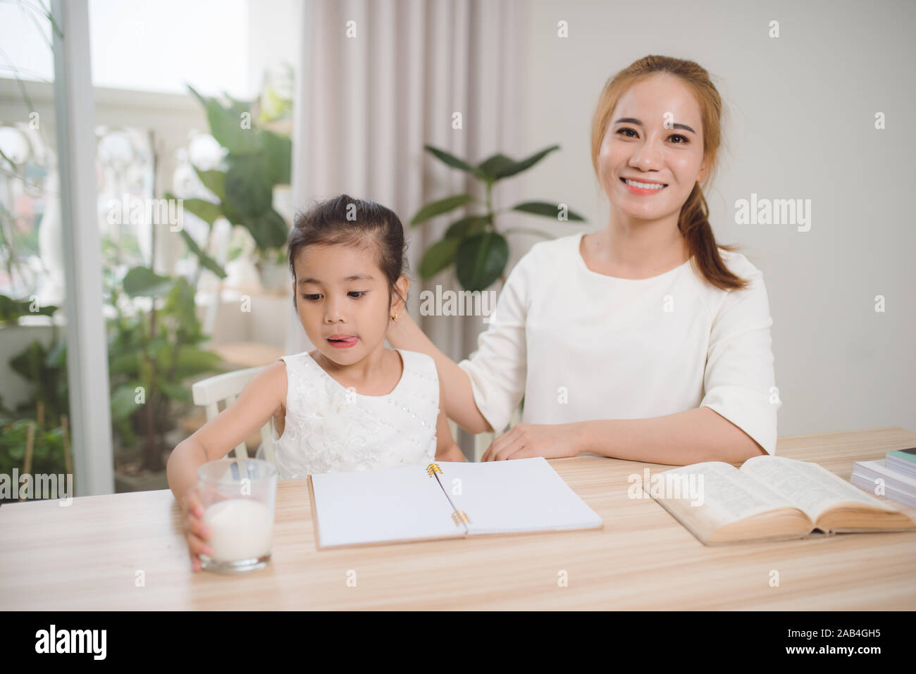 mother-teaching-daughter-how-to-write-stock-photo-alamy