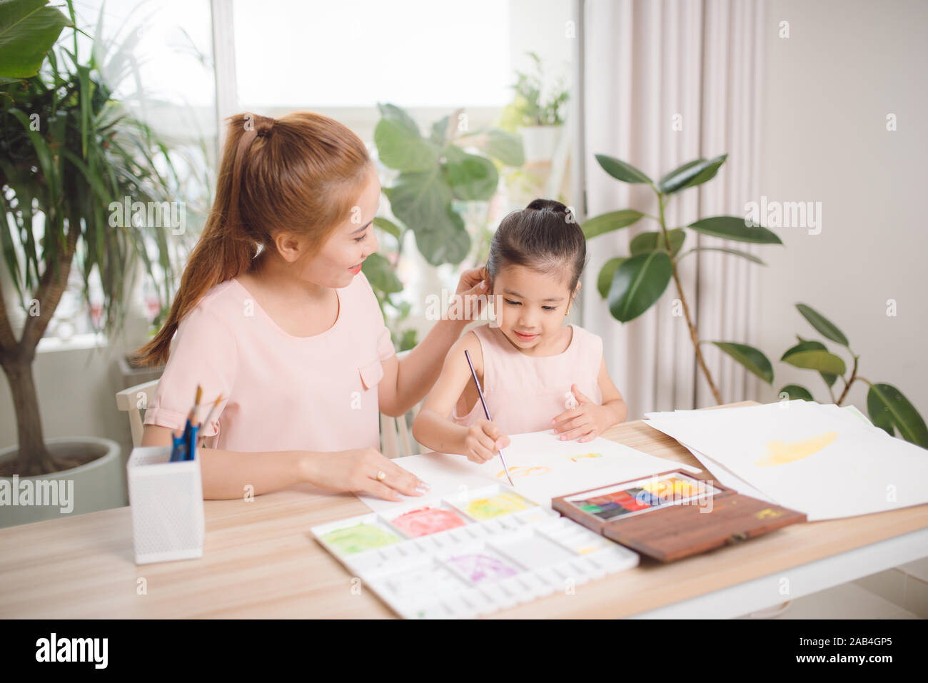 Little girl painting with her mother laying in livingroom Stock Photo ...