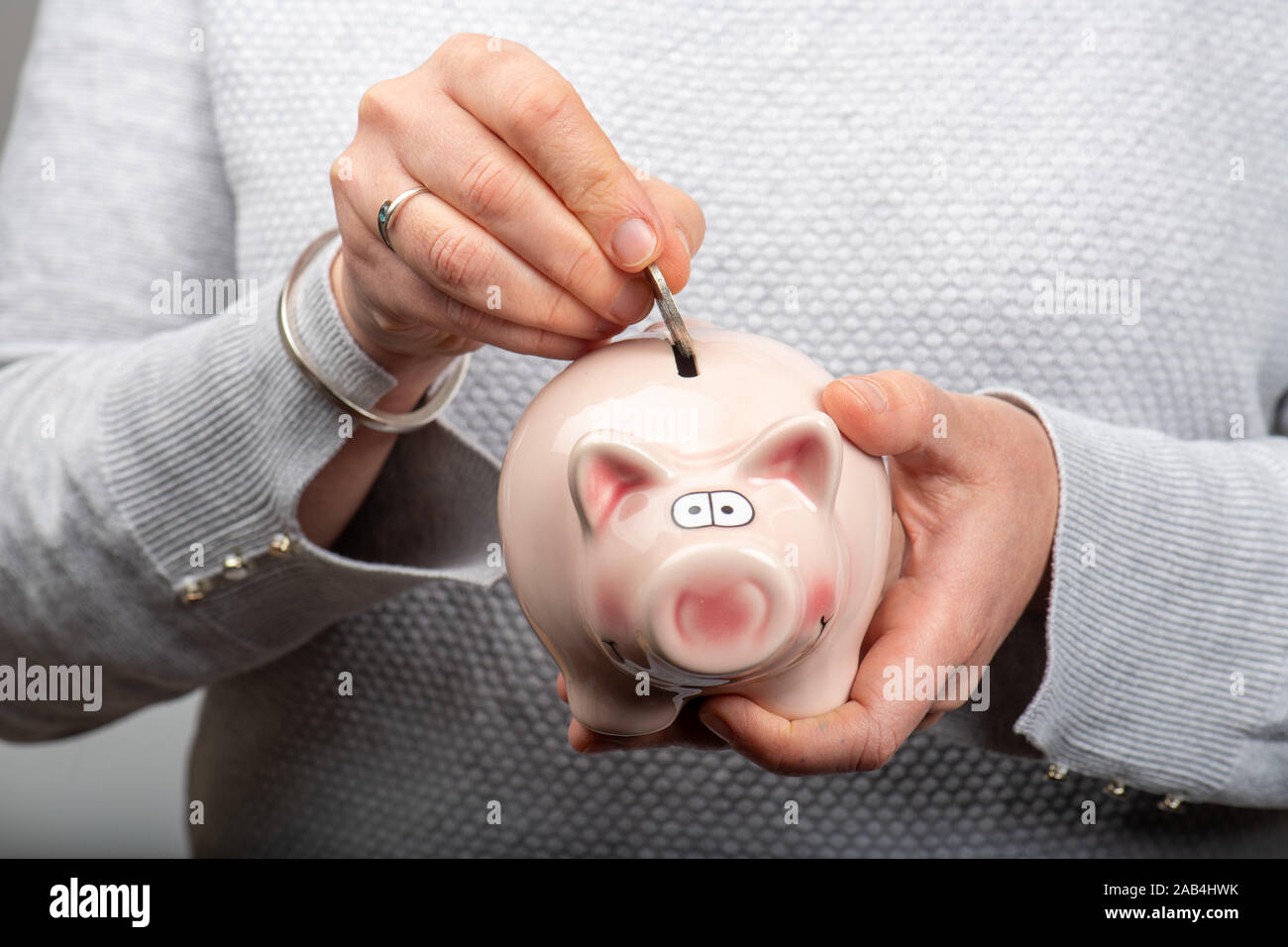 Putting a coin into a piggy bank hi-res stock photography and images ...