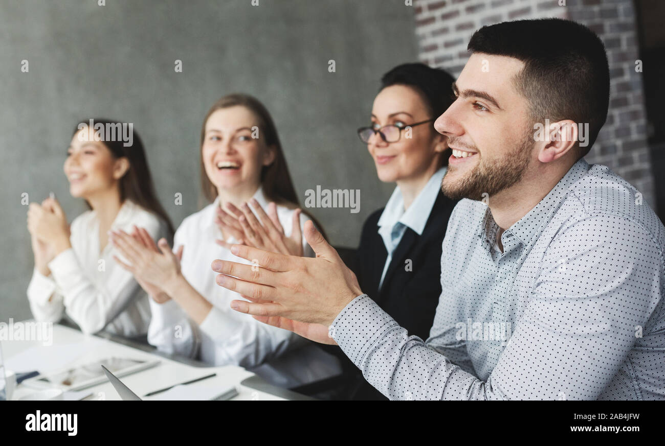 Motivated business team applauding after lecture to speaker Stock Photo