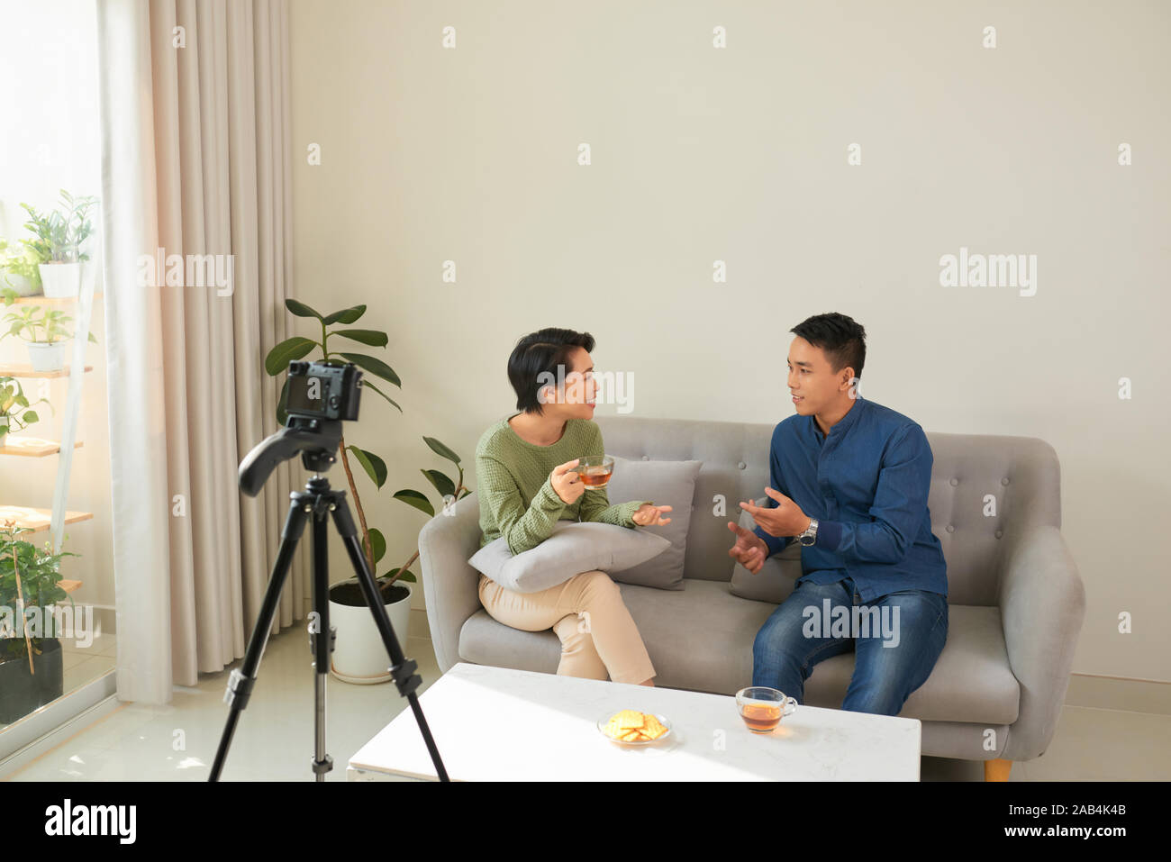 Best business vlog. Young woman and man talking while making new video indoors Stock Photo