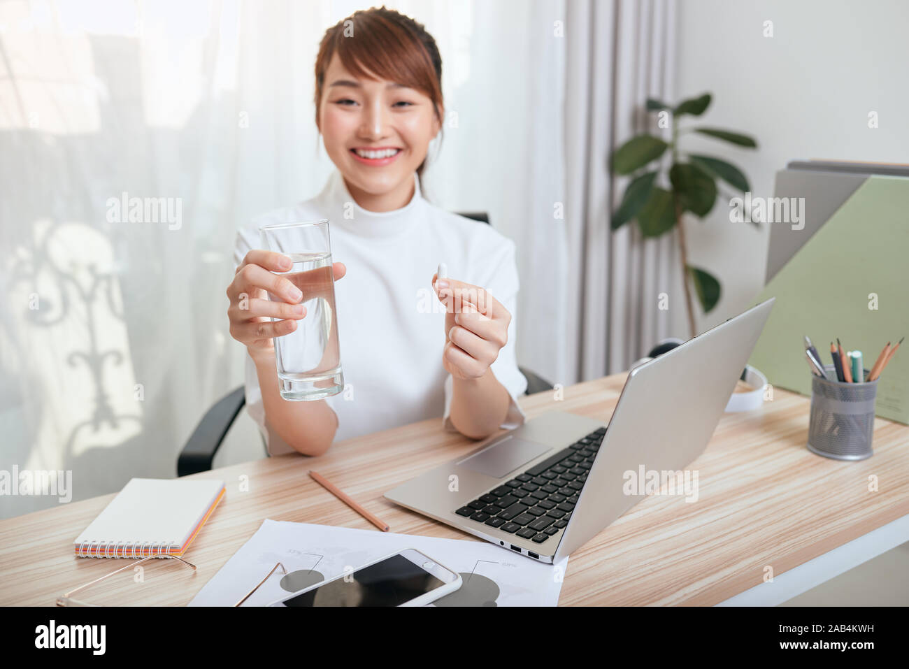 Business woman drinking water and taking medicine. She feels like sick Stock Photo