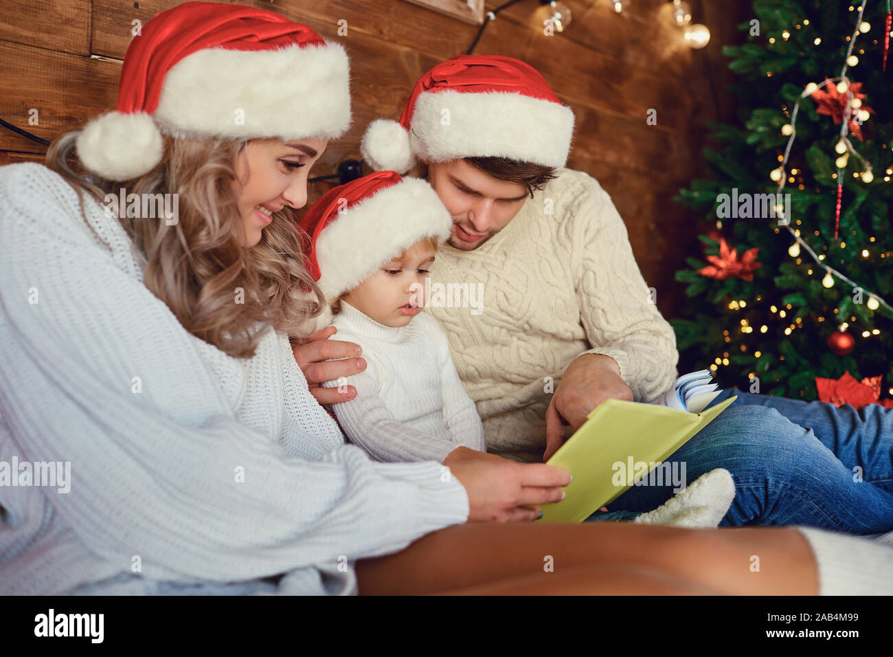 Happy family reading a book at Christmas. Stock Photo