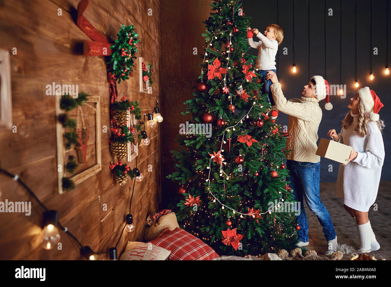 Loving family decorating Christmas tree together Stock Photo