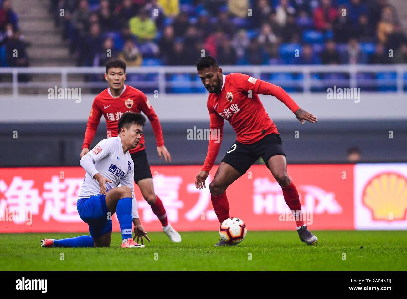 Brazilian-born Portuguese football player Dyego Sousa of Shenzhen F.C., right, keeps the ball during the 28th round match of Chinese Football Association Super League (CSL) against Tianjin TEDA in Tianjin, China, 23 November 2019. Tianjin TEDA slashed Shenzhen F.C. with 3-0. Stock Photo